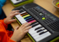 drama school child playing paino keyboard